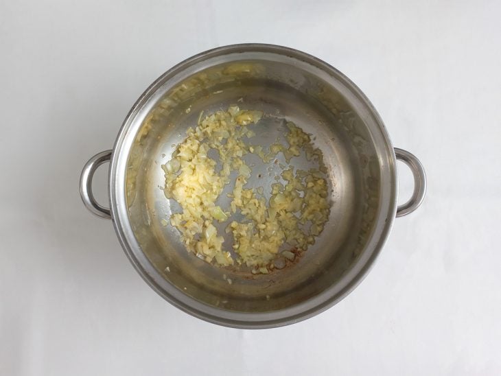 Uma panela com alho e cebola refogados.