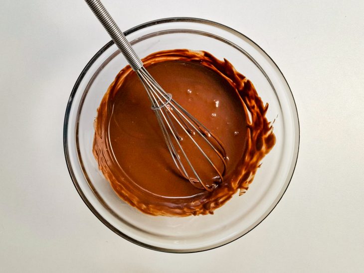 Numa tigela, o chocolate derretido.