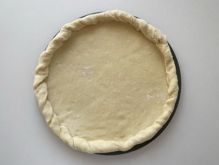 Massa moldada na forma de pizza.