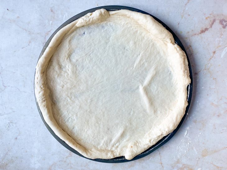 Na forma de pizza, a massa aberta no formato.