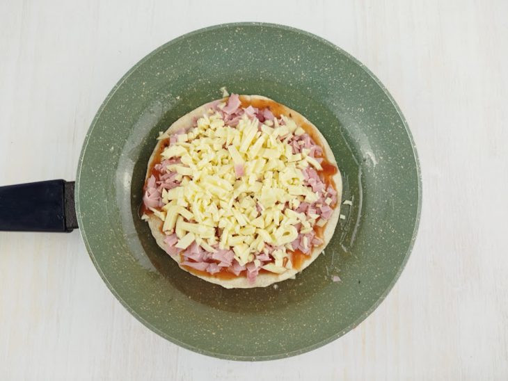 Recheio acomodado sobre o wrap na frigideira.