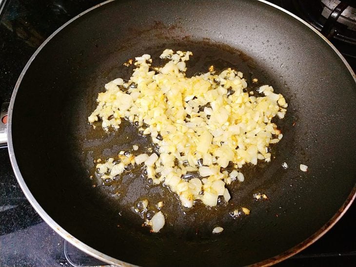 Panela com ingredientes sendo refogados.