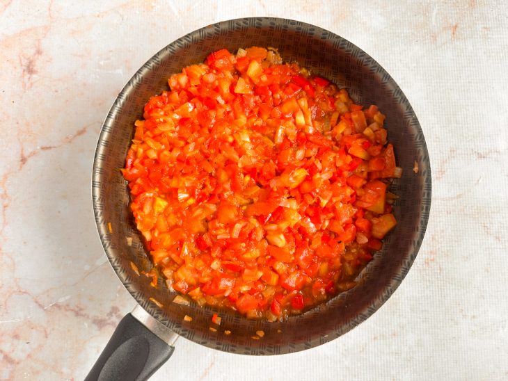 Tomate adicionado ao molho com sal e pimenta-do-reino.