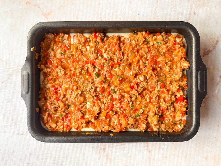 Molho de sardinha distribuído sobre a massa.