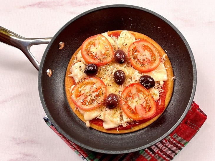 Uma frigideira contendo uma pizza low carb de frigideira.