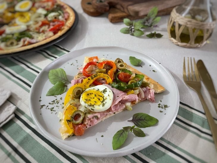 Pizza pronta, fatia servida em prato.