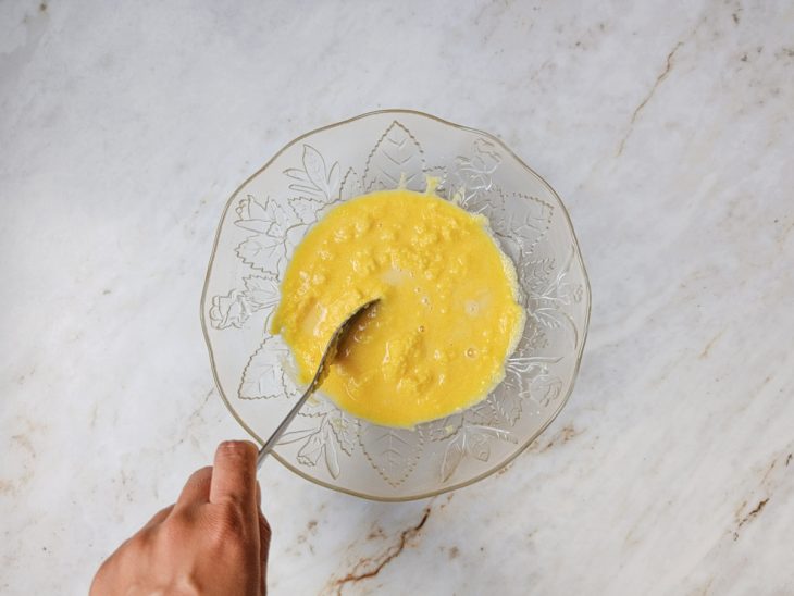 Fubá sendo dissolvido em água numa tigela de vidro.