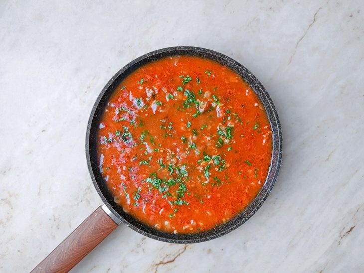 Molho de tomate, água e temperos adicionados na panela.