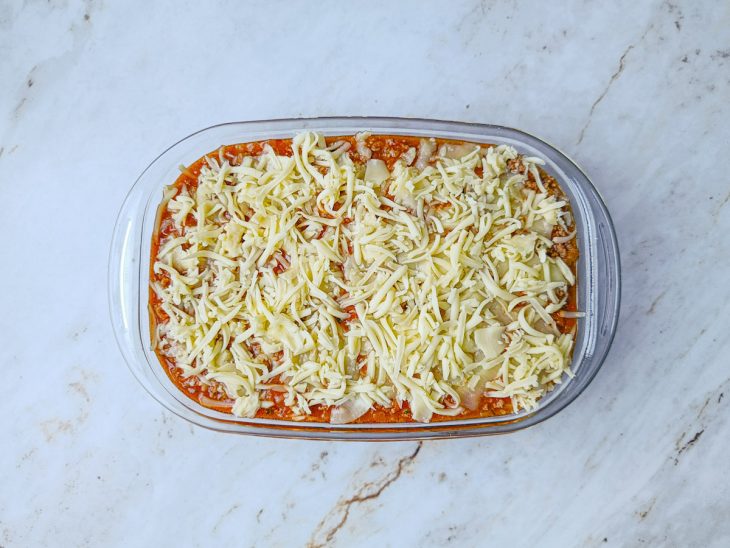 Camadas de molho e carne moída feitas no refratário.