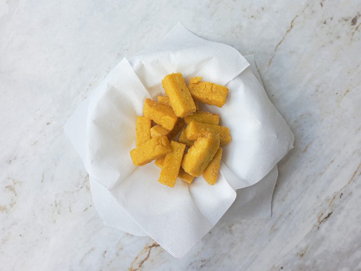 Polentas fritas sobre um papel toalha.