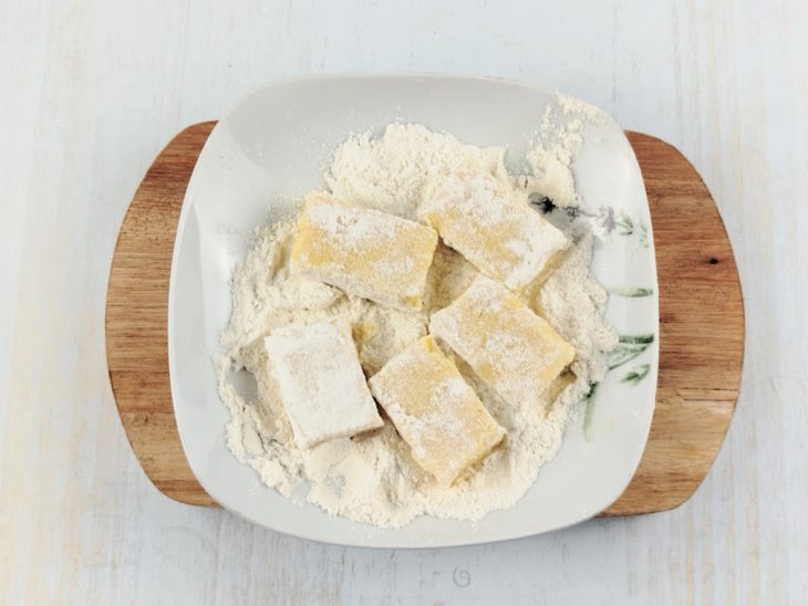 Pedaços de polenta passados na farinha de trigo.