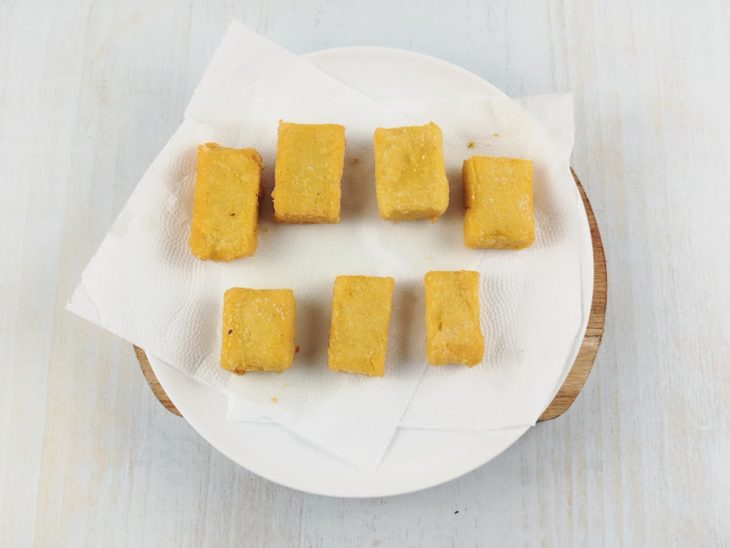 Polentas fritas em um prato com papel toalha.