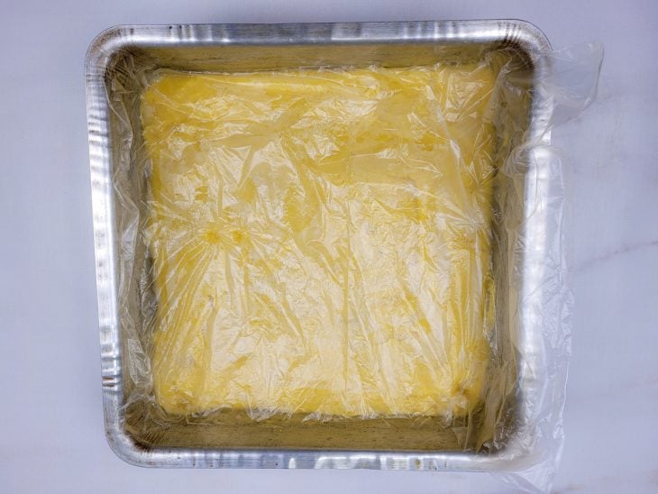 Uma forma contendo polenta coberta com plástico filme.