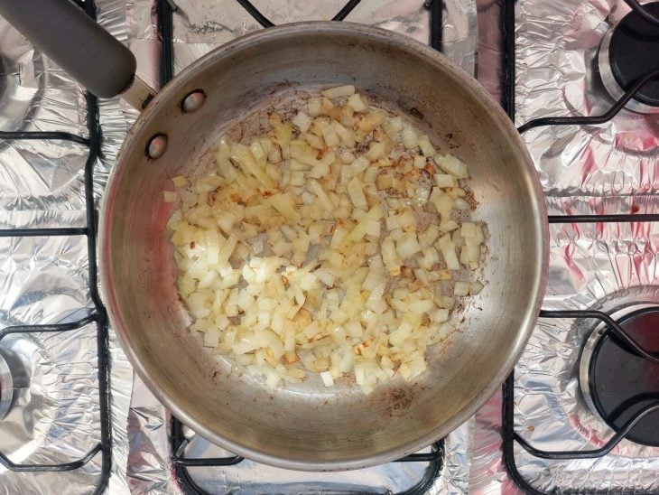 Uma panela com azeite e cebola a dourar.