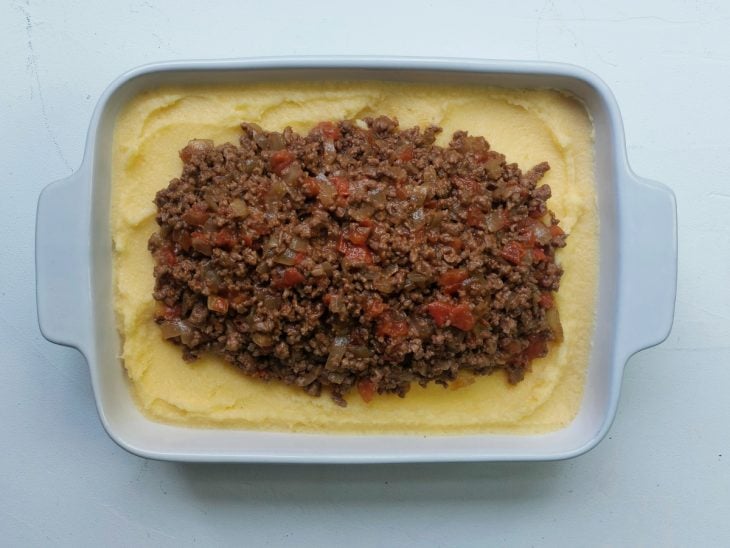 Uma travessa contendo polenta mole com carne moída.