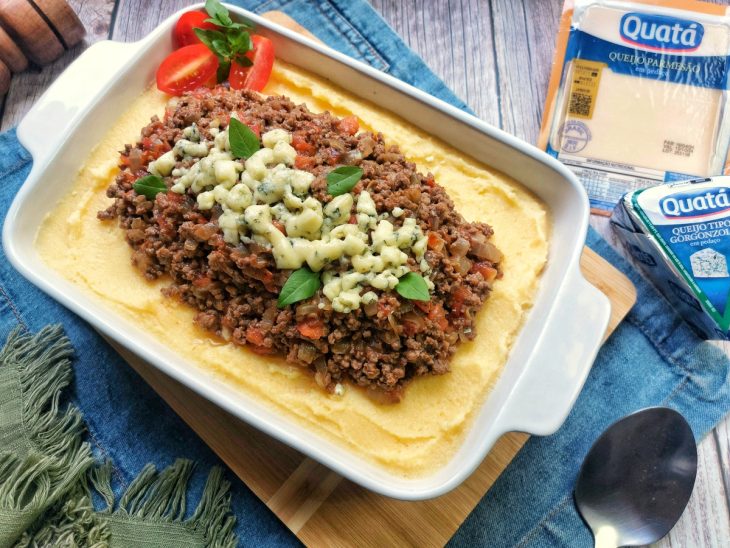 Uma travessa contendo polenta mole com carne moída.