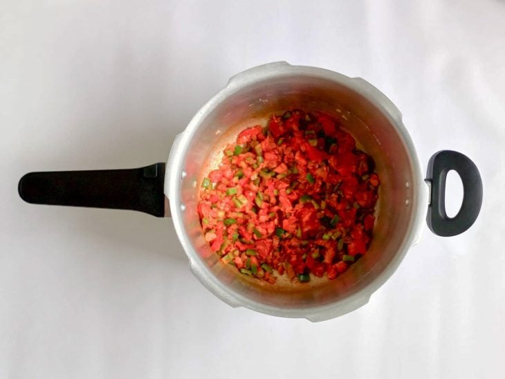Ingredientes e temperos adicionados e incorporados na panela de pressão.