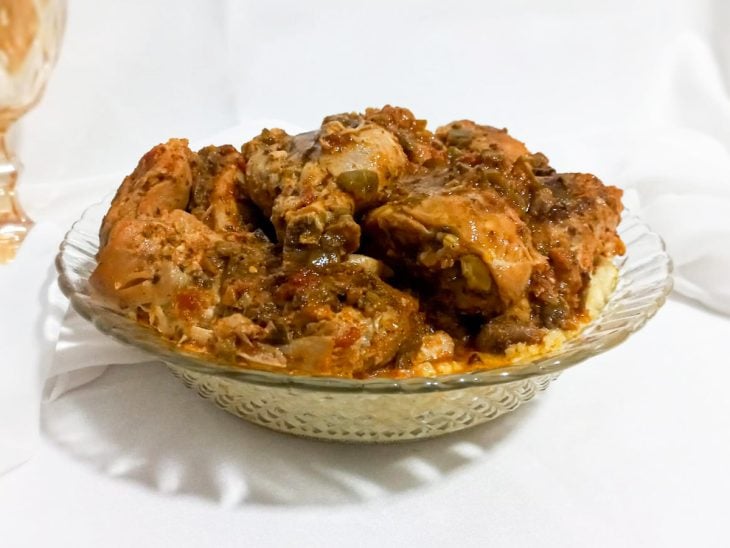 Polenta simples e rápida servida com frango em um recipiente de vidro.