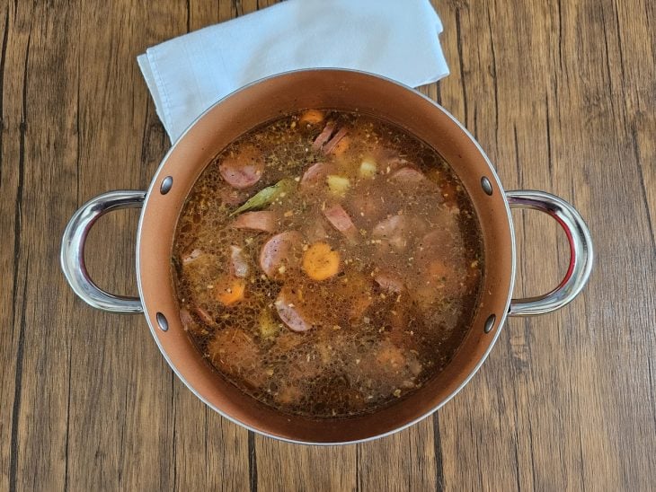 Uma panela cozinhando legumes e carnes.