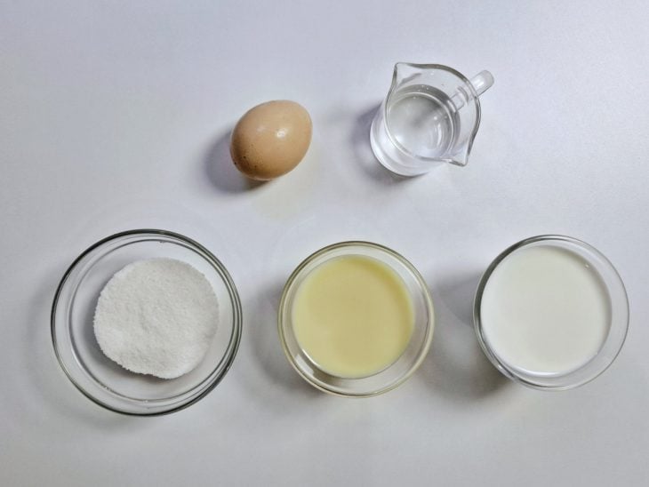 Ingredientes para a receita de pudim de caneca separados em uma bancada.