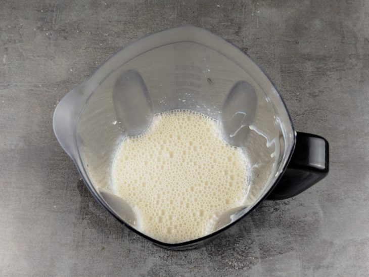 No liquidificador, o leite condensado e o creme de leite batidos.