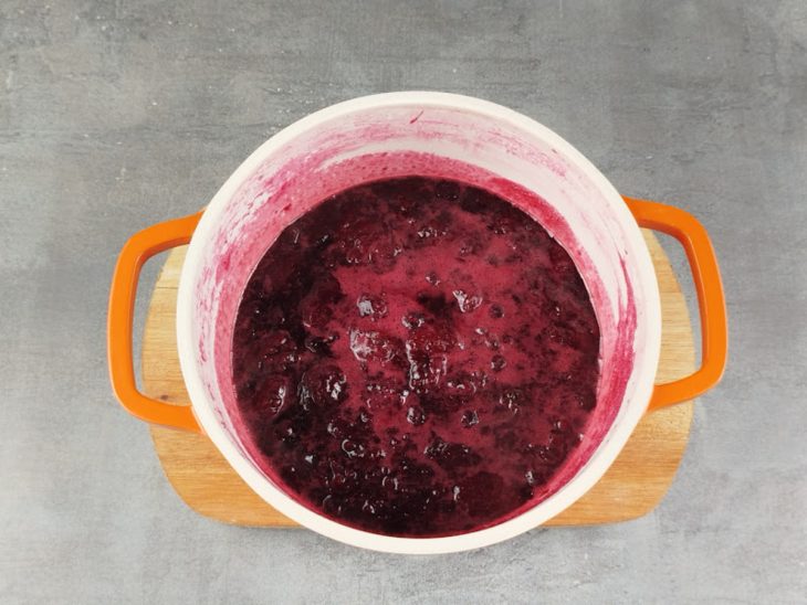 Numa panela, o açúcar, a água e as frutas vermelhas.