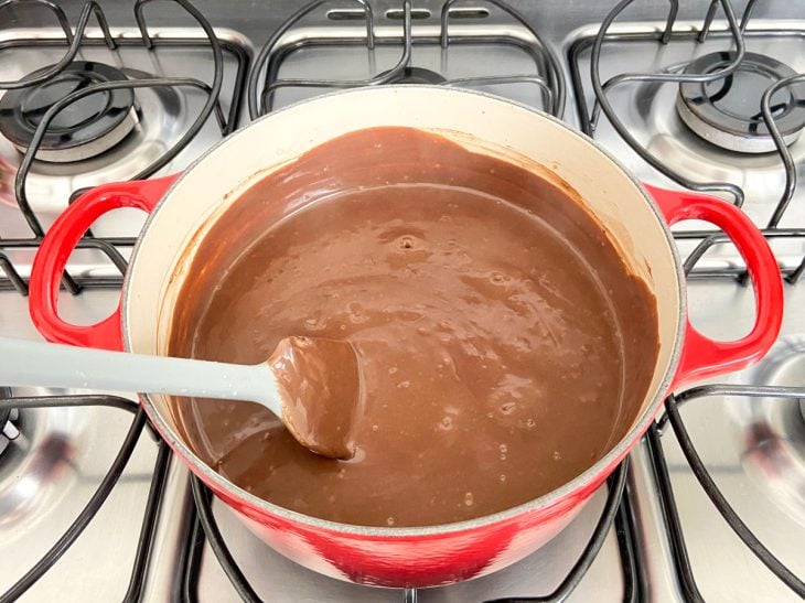 Uma panela contendo a mistura de leite condensado, chocolate em pó, amido de milho, leite e gemas.