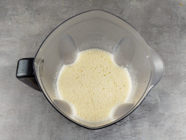 Leite condensado, ovos e suco de laranja sendo batidos no liquidificador.