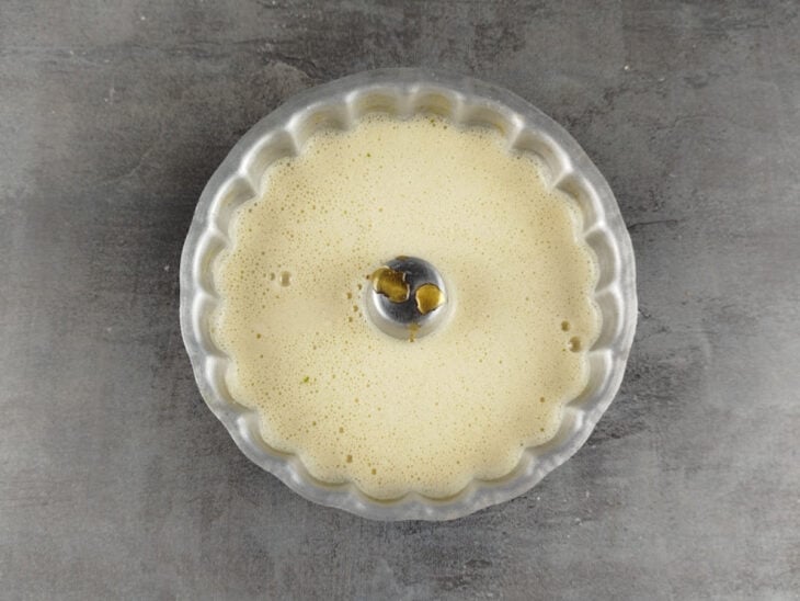 Creme do pudim sendo despejado na forma caramelizada.