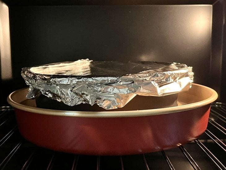Uma forma, coberta com papel alumínio, no forno.