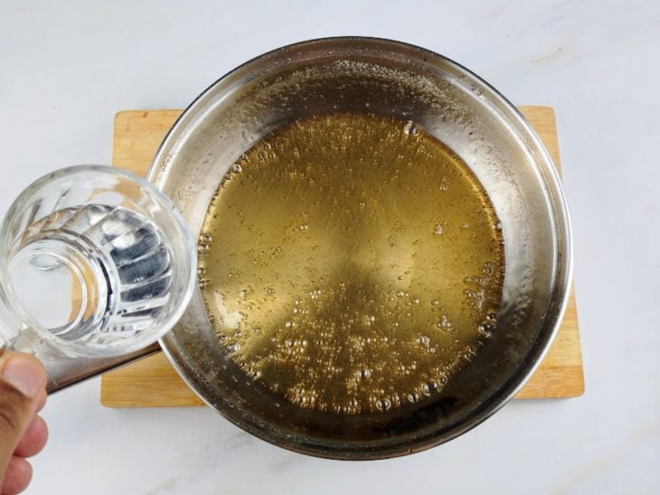 Água adicionada a panela com açúcar.