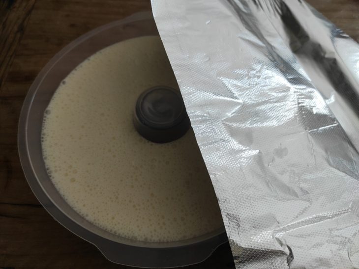 Mistura acomodada na forma coberta por papel-alumínio.