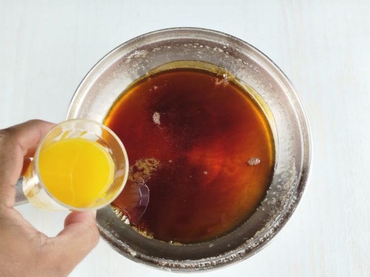 Água e suco de laranja sendo adicionados na calda.