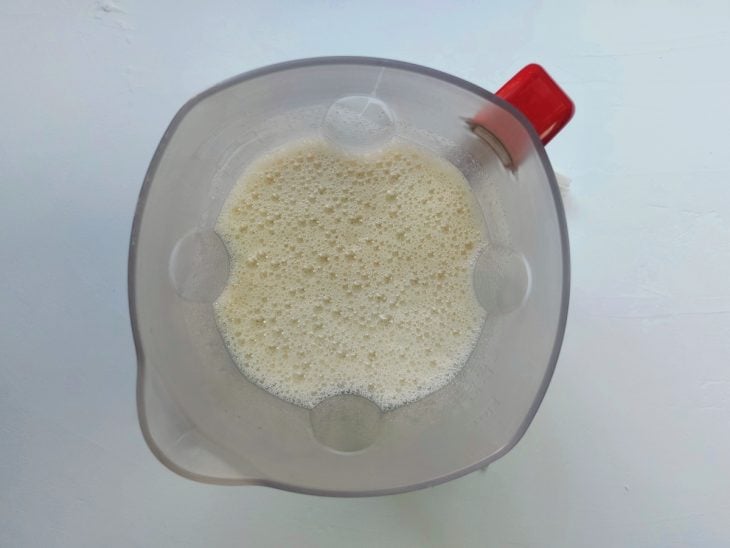 Um liquidificador com pão umedecido, leite, ovos e açúcar.