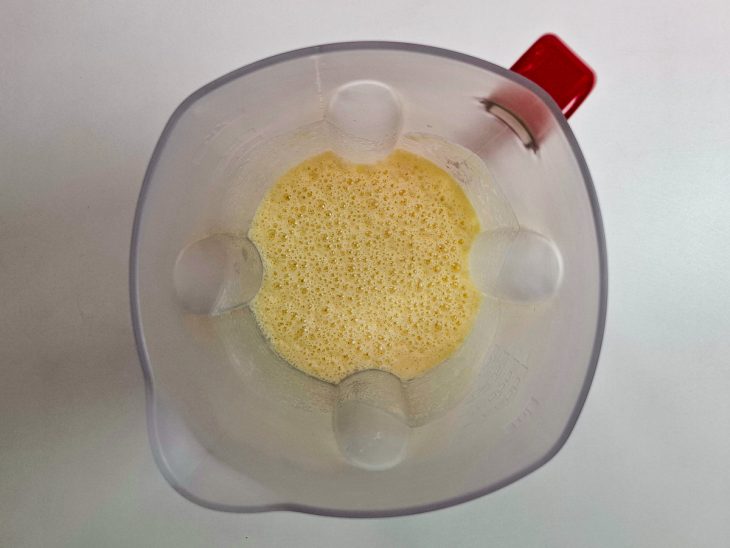 Ovos, leite de coco e leite condensado batidos no liquidificador.
