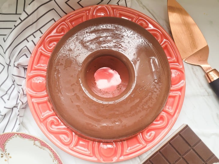 Pudim gelado de chocolate desenformado em um prato.