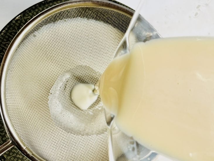 Mistura do pudim sendo despejada na forma com caramelo.