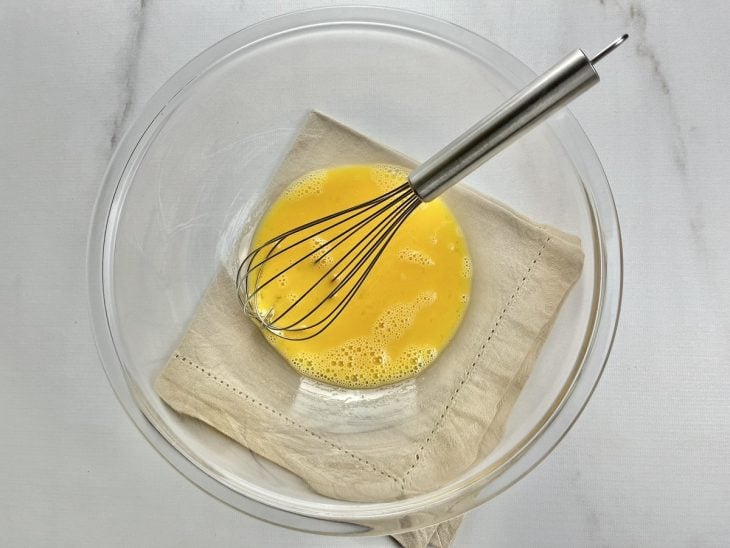 Um recipiente contendo os ovos batidos.