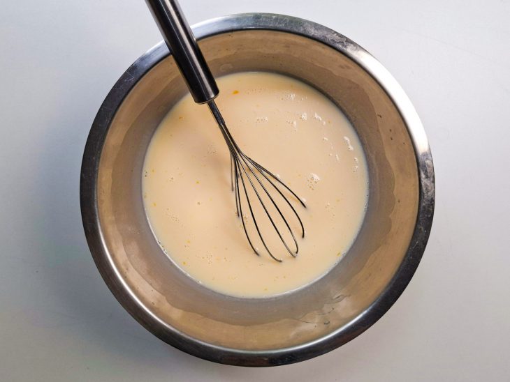 Ovos batidos com fouet em uma tigela.