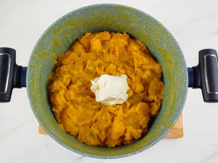 Requeijão adicionado a panela com abóbora e leite.
