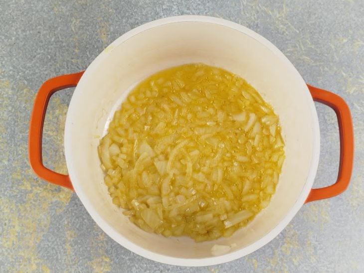 Cebola sendo refogada na manteiga derretida na panela.