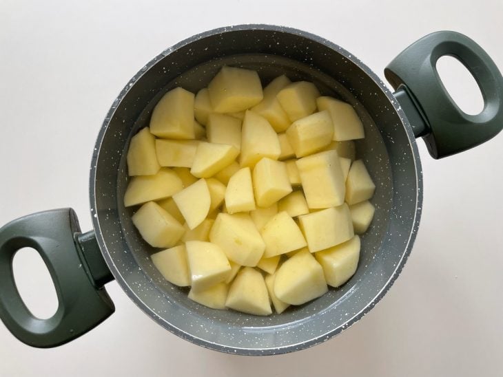 Batatas cozinhando em panela com água.