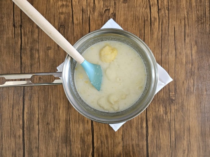 Uma panela com as batatas amassadas, manteiga e leite.