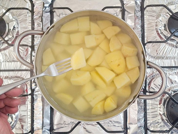 Garfo com um pedaço de batata espetado.