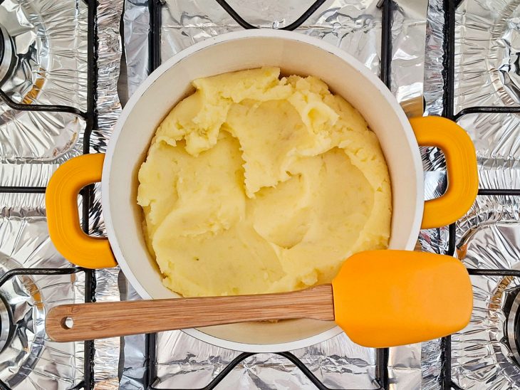 Purê de batata com manteiga adicionada na panela.