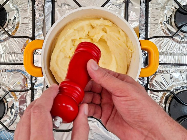 Purê sendo temperado na panela.