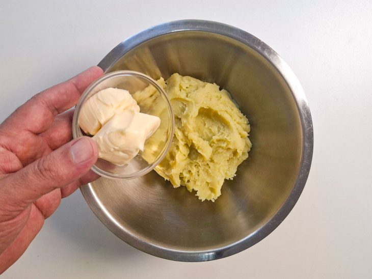 Cream cheese e sal sendo misturados ao purê de batata-doce até ficar cremoso.