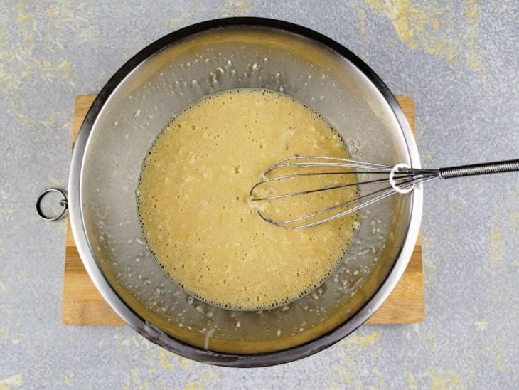 Gemas, leite condensado e parmesão adicionados ao recipiente.
