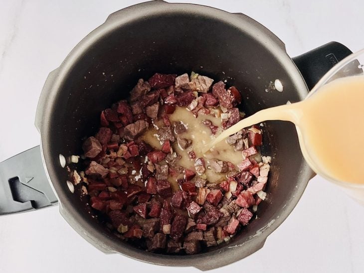 Caldo de camarão adicionado a panela.