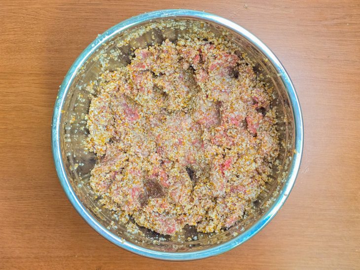Carne moída adicionada na tigela com trigo.